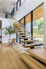 Set on top of a forested ridge separating downtown Portland and the suburban sprawl of Beaverton, OR, Wildwood by Giulietti / Schouten AIA Architects is a rural retreat and primary residence hidden within the metro area of the Pacific Northwest.&nbsp;The floating staircase features glass guardrails and white oak treads to match the hardwood floors.&nbsp;
