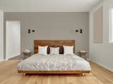 The walnut master bed frame is custom by Matt Eastvold. The sconces are by Brendan Ravenhill.