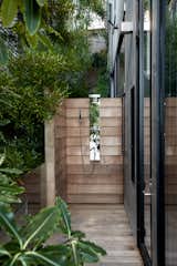 An outdoor shower is concealed in the side yard and features a weathered 
cedar slat enclosure.