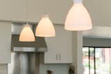 Minimal pendants add warm, intimate lighting at the oversized kitchen island.