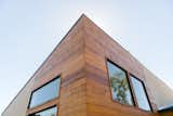 Exterior cedar siding adds asymmetrical interest at the new angled roof at the front addition.