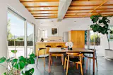 An open floor plan with large sliding glass walls and windows on all sides.