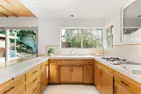 Simple kitchen with tile counters and wood cabinets.