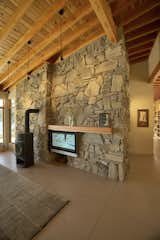 The tv slides into a slot behind the wood stove when not in use.