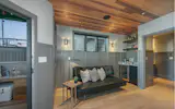 The entryway greets guests with a sitting area, fully stocked bar, and access to an exterior covered deck.