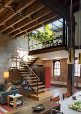 A custom steel stair repurposes timbers from the old roof joists as treads and landings.
