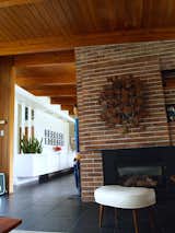 Calgary Trend House looking past the Claybank Brick fireplace to the built in sideboard in the dining room  Photo 11 of 21 in Calgary Trend House by Mike Kurtz
