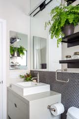 Crisp neutrals in this modern bathroom are filled with visual texture and warmth. Vanity and Sink: Wetstyle; Faucetry: Purist by Kohler; Sconce: Stiletto by Sonneman; Shelves: West Elm; Wall Tile: Savoy Mosaic in Graphite by Ann Sacks.