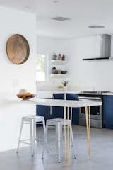 The blue theme continues in the kitchen along with a brass legged built in breakfast table.