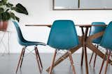 Here we see an original mid century table paired with new modern chairs and accented with a bohemian pot and side table. 