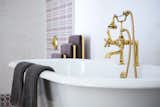 Custom brass fixtures and a clawfoot tub give both a modern and classic feel.