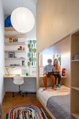 The desk spans both rooms between the window and the bed structure