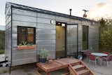 The decking unit in front of the tiny house is modular and can be linked to multiple additional decking units.