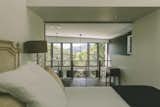 The bedroom captures the view over the void of the living space and out into the treetops.