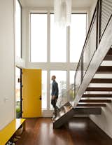 view of the window wall and stair in the double-height front entry, custom light by Larissa Sands
