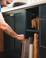  an open shelf holds cutting boards and baking sheets