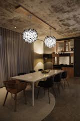 What once was a warehouse is now a luxury condo. This dining room features a pair of Asteroid Pendants.  Photo 1 of 2 in Rustic Luxury by Boyd Lighting