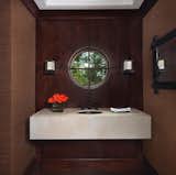 Designed by Christine and Jacques Rouviere for Boyd Lighting, the LED Glow Sconce has the look of an elegant ice cube perched on a ledge. In a dark room it is a virtual beacon. Available in two metal finish options. Dimmable. Interior design by Carrie Long Interiors. Photo by Beth Singer. #sconce #bathroomsconce #lighting #modernlighting #bathroomlighting