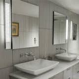 Designed to be recessed in a bathroom mirror as an unobtrusive, architectural light source, the Emanation Sconce also looks great surface mounted in dressing rooms, closets and hallways. Designed by Tony Garret for Boyd Lighting, this fixture has become the hottest selling fixture in our line. ADA compliant and available in five mirrored diffuser pattern options. Flourescent and LED versions available, Three standard lengths. Photo by Debra Butler. #bathroomsconce #sconce #mirroredsconce #lighting #bathroomlight
