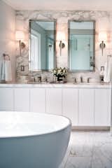 This slick bathroom by Powell & Bonnell features a trio of Pacific Heights Sconces designed by Barbara Barry for Boyd Lighting. With its vertically faceted form, the Pacific Heights wall sconce is a classic workhorse fixture for residential bedrooms, bathrooms, living rooms, dining rooms, libraries and offices. Aggressively priced for commercial and hospitality spaces. Available in three metal finish options. Photo by Ted Yarwood. #lighting #bathroomlighting #bathroom #sconce #bathroomsconce #shadedsconce #lightingdesign #classiclighting