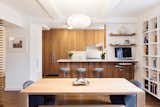 Custom teak cabinetry creates a clean modern look with the enlarged kitchen island opened onto the dining area; a small workstation is created at the right