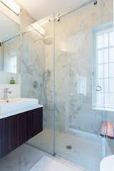 Compact bathroom with a spacious shower and teak seating.  Recessed niches take advantage of every square inch at the vanity