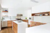 Black walnut cabinetry with white lacquer upper cabinets; custom accent walnut shelving units