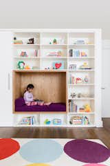 Kids Room, Shelves, Bookcase, Playroom Room Type, Bench, Toddler Age, Storage, Dark Hardwood Floor, Neutral Gender, Bedroom Room Type, and Rug Floor Child's bedroom with custom cabinetry and reading nook  Photos from 19 Cozy Nooks That Radiate Charm and Comfort