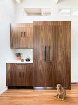 The fridge is concealed behind grain-matched walnut doors (and a very cute dog).