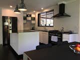 The kitchen island bench top consists of a 5mm thick piece of raw black steel that has been treated with Penetrol. The five cupboards are made of the same material and contain wired industrial glass.  These two features were something that just couldn't be comprehended by kitchen companies in the area.  The two island pendants were recycled from an old factory in my home town and had very little work done to them prior to installation.