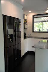 The black stainless steel fridge was chosen to complement the raw steel island bench top.  