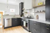 Canyon Creek Burnished Indigo cabinets that contrast the white walls and marble-mimicking quartz countertops. Brass fixtures and pulls.