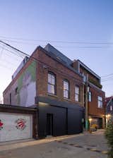 Front elevation from Laneway with blackened steel panels forming ground related entry. 
