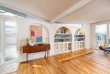 An arcade under clerestory windows is a unique architectural feature to this home, and includes ample built-in shelving with lighting above.