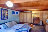 The spacious master bedroom was added after the home was built, and was designed by the home’s original builder and designer, Edward Hawkins. The same architectural language of wood paneling, stained tongue-and-groove ceilings, and exposed pumice block extends into the addition (although previous owners added drywall over the original pumice block in this room).