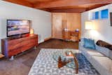 The living space was expanded into the original garage and included an addition behind the house, both of which were also designed by Edward Hawkins. The same simple architectural language was extended into this space, including wall paneling, stained tongue-and-groove ceilings and exposed beams.