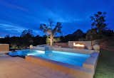 Pool interior is a custom blend glass tile with black granite on the perimeter overflow area of pool. #pooldesign #glasstile #arizona #outdoorliving