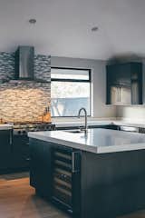 Kitchen, Concrete Counter, Medium Hardwood Floor, Recessed Lighting, Glass Tile Backsplashe, Undermount Sink, and Wine Cooler  Photo 4 of 12 in Crestline by ANACAPA