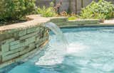 A water feature is a great way to enhance your outdoor space. This waterfall has seating below so you can enjoy a soothing water massage.