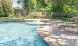 This pool took advantage of the shallow wading area by adding a fountain that can be turned on and off, making the outdoor space the ideal place to relax both in and out of the pool.  Photo 8 of 11 in A Pool In Austin Built For Relaxing by TimberTown