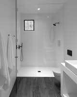 The minimalistic bathroom at the center of the studio separates the sleeping area from the living area .
