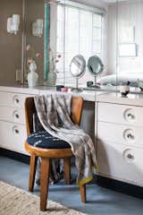 Bedroom, Concrete Floor, Wall Lighting, Chair, and Dresser The master bedroom's steel vanity is one of several original built-in design features.  Photo 9 of 13 in The Decatur Lustron by Jeanee Ledoux
