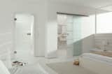 Glass modern barn doors allow for light to pass through while still creating privacy in a bathroom setting.Get inspired -> www.bartelsdoors.com