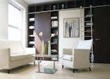 a stainless steel library ladder being used in a modern living room. Get inspired -> www.bartelsdoors.com