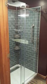 I used this same glass door in both the master and the full bath projects. It's the EnigmaX from Dreamline sourced at Lowe's. The external hardware and clean lines embody exactly the modern feel that I was going for in both spaces. The aluminum trim is just stock from Lowe's with a 90 degree corner the right depth to cover the glass tile edge. I buffed the aluminum a bit with a fine grit sandpaper and glued it in place with clear silicone. It picks up the drain cover, the door hardware, the basket assembly, the towel hook, and the shower head. The starkness of the glass and metal are softened by the richness of the paint and the warmth of the wood tones.
 