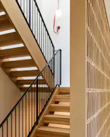 Open tread wood stair with metal guardrail and masonry screen