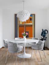 A vintage chandelier hangs over an Eero Saarinen round table and a set of Strike chairs by Arrmet Studio.