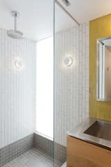 The lower bathroom was transformed as well and Murdock added another glass panel to this space to bring in light from the window in the adjacent room.  The mustard yellow tile from Heath Ceramics adds a fun pop of color and Murdock's tile layouts were meticulously planned to seamlessly intersect with adjacent materials and cabinetry.