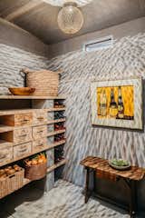Wine enthusiasts will be delighted to find a temperature controlled wine cellar and larder located just off the kitchen.  Artwork by Raimonds Staprans sits above an antique table from France.  Moroccan lighting from Tazi  brings a special element of shadow play to the space.