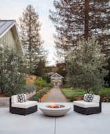 Cozy seating around a fire, with the garden cottage and chicken coop in the distant view.  By Arterra Landscape Architects  Photo 5 of 9 in Talk of the Neighborhood by Arterra Landscape Architects